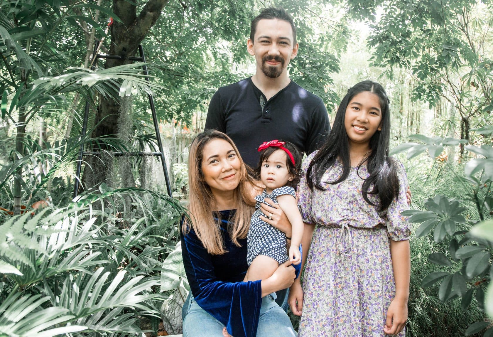 A relocating family of four together in a lush tropical garden in Phuket